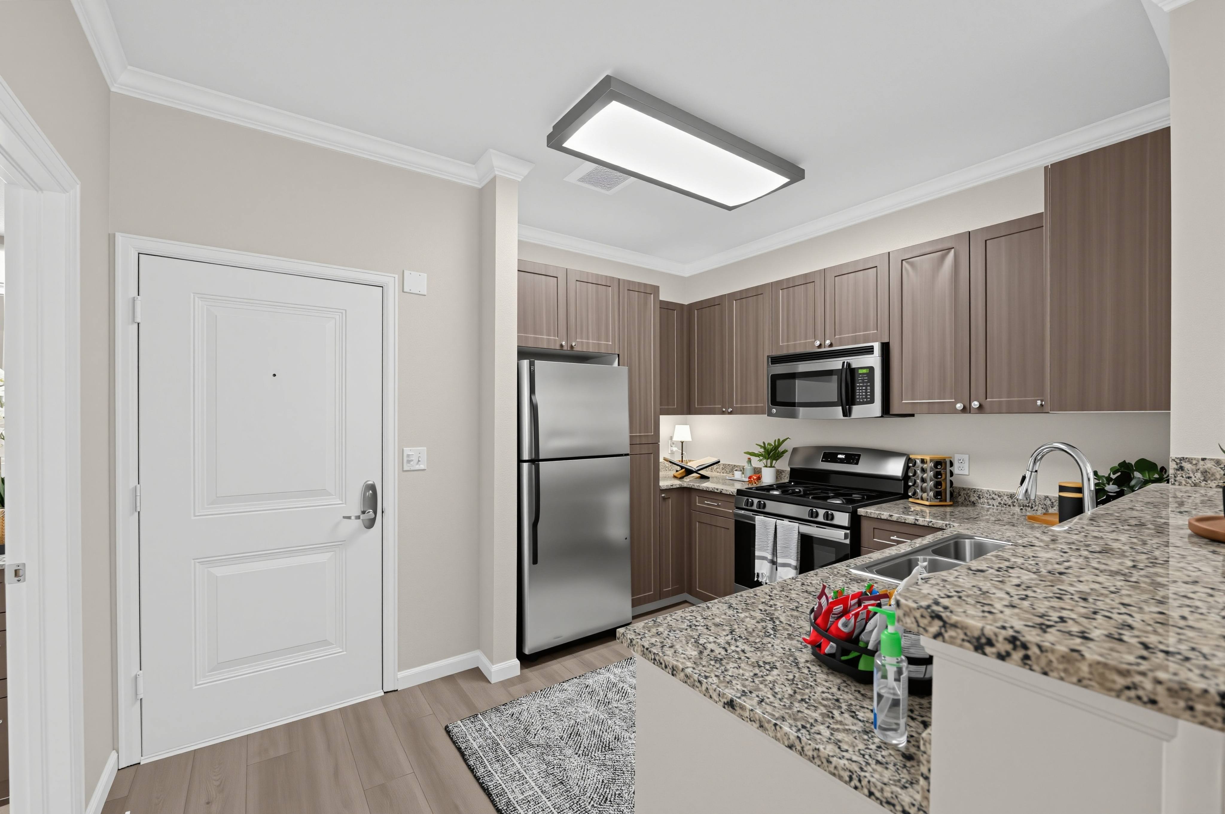 A kitchen with a refrigerator, microwave, and oven.
